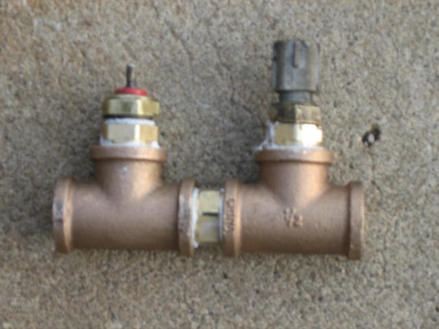 Two brass valves connected by a T-fitting with "1/2" marking