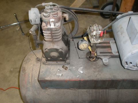 2007 Ford Bronco - Close-up of an old air compressor, showing its motor, pump, and pressure gauges.