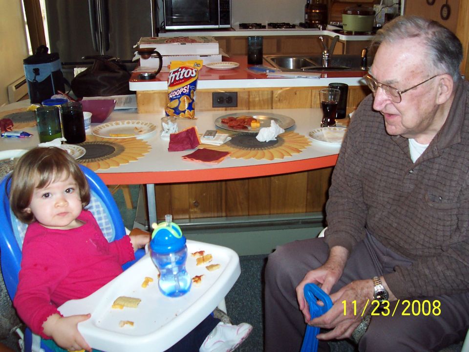 Baby in high chair and man at table with food, dated 11/23/2008