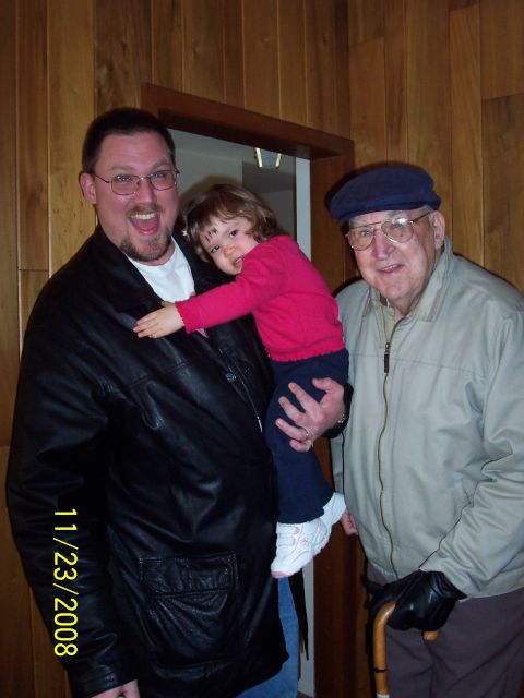 2000 Ford Crown Victoria - A man holds a child while standing with an older man, with a date stamp visible in the lower left corner.