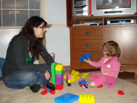 2000 Ford Crown Victoria - A woman and a child are playing with large building blocks on the floor.