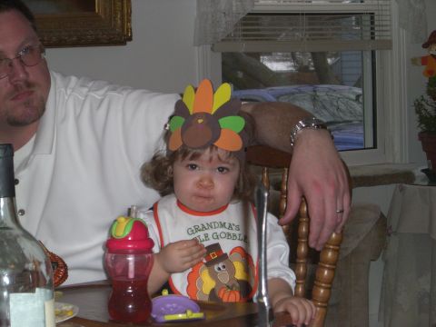 2000 Ford Crown Victoria - A young child dressed for Thanksgiving sits at a table with a bottle and a plate.