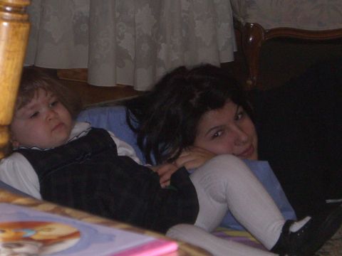 2000 Ford Crown Victoria - A child and an adult are lying on the floor, with curtains and furniture in the background.