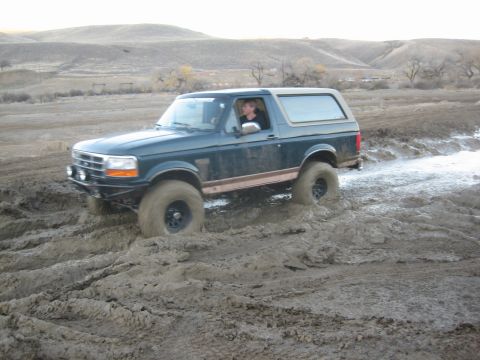 1995 Ford Bronco - Ford Bronco navigating a muddy off-road trail.