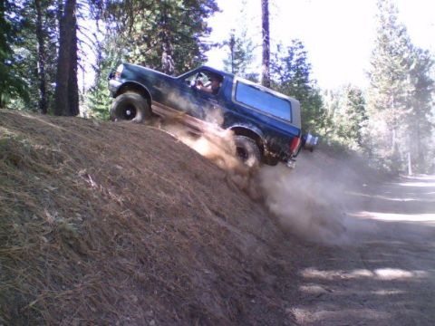 1995 Ford Bronco - Ford Bronco navigates a steep, dusty off-road trail.
