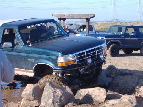 1995 Ford Bronco - This Ford Bronco is tackling a rocky obstacle course with other vehicles nearby.