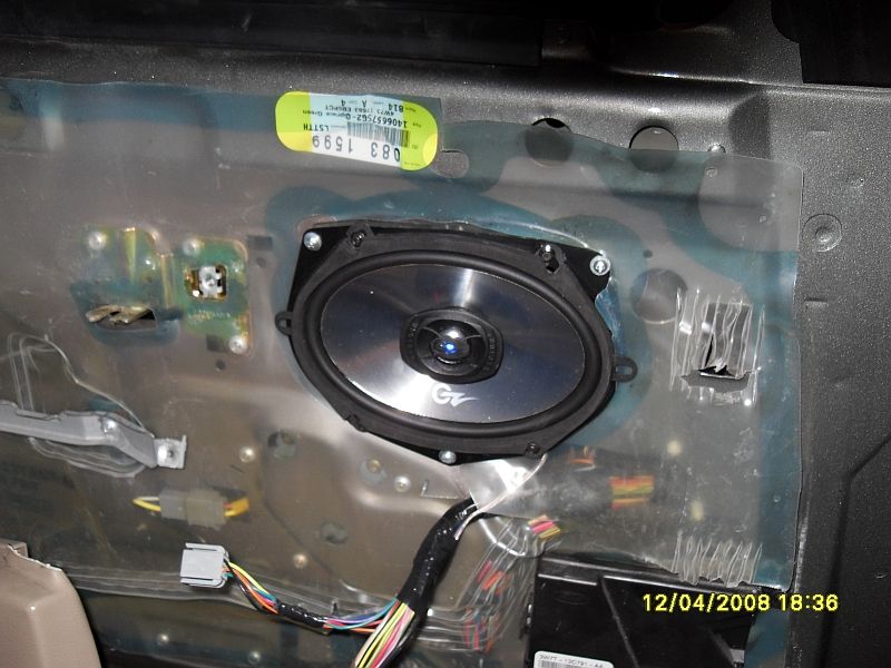 Car door panel interior showing a speaker and wiring harness. Date stamp reads 12/04/2008