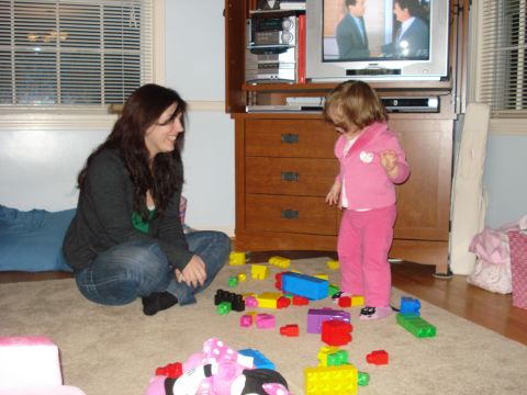 2000 Ford Crown Victoria - A woman and a young child are playing with colorful building blocks on the floor in a living room.