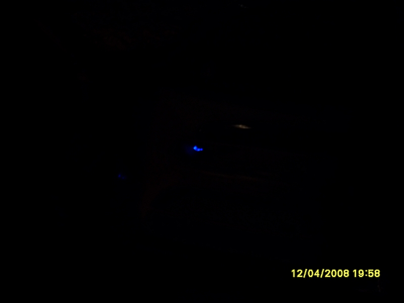 Rear view of a Mercury Marquis with blue underglow lights at night.