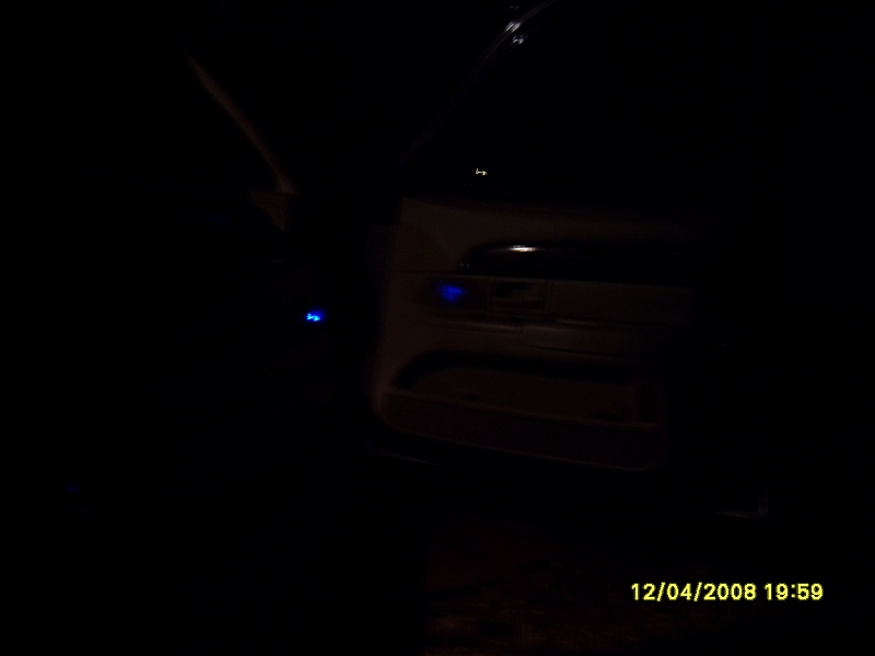 Interior of a dark vehicle with blue accent lighting on the door panel, timestamp 12/04/2008 19:59.