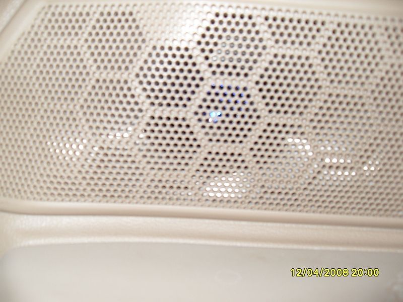 Close-up of a car speaker grille with a blue light, timestamped 12/04/2008 20:00.