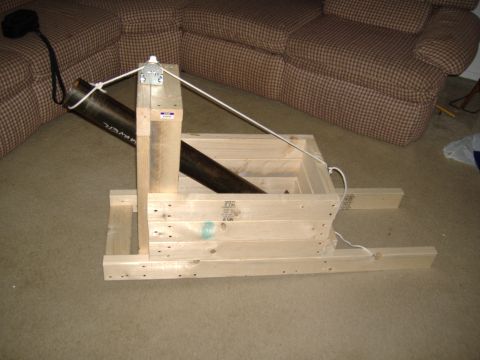 1988 Ford Bronco - A wooden frame structure with a metal pipe is set up on a carpeted floor, with a portion of a sofa visible in the background.