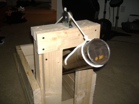 1988 Ford Bronco - A wooden apparatus with a metal pipe and rope is set up on a carpeted floor. The background shows a dimly lit room with various objects.