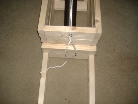 1988 Ford Bronco - Shop-built jig or stand made from unfinished dimensional lumber sitting on beige carpet, with a black steel tube running through the upper…
