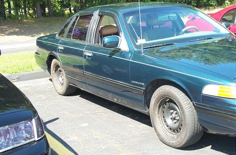 1991 Ford LTD Crown Victoria - Photograph of a green Ford Crown Victoria sedan parked outdoors, not a technical document.