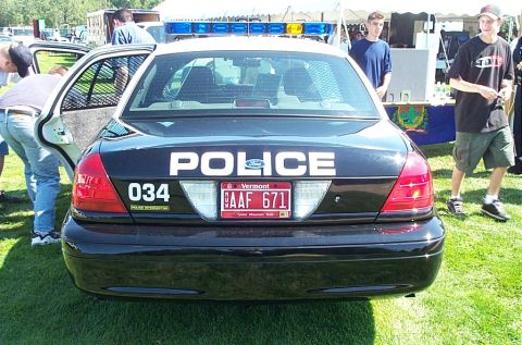 1991 Ford LTD Crown Victoria - Rear view of a black police car with "POLICE" text and a Vermont license plate.