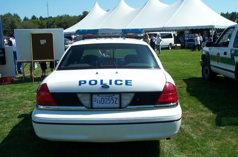 1991 Ford LTD Crown Victoria - Photograph of the rear of a white police Crown Victoria parked at an outdoor event, not a technical document.