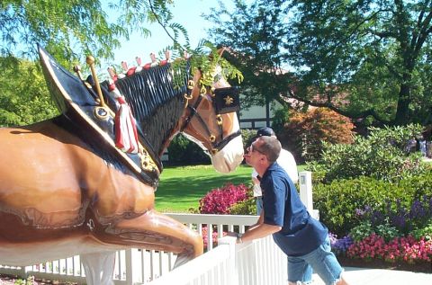 1991 Ford LTD Crown Victoria - Photograph of a man posing with a life-size Clydesdale horse statue in a landscaped garden.