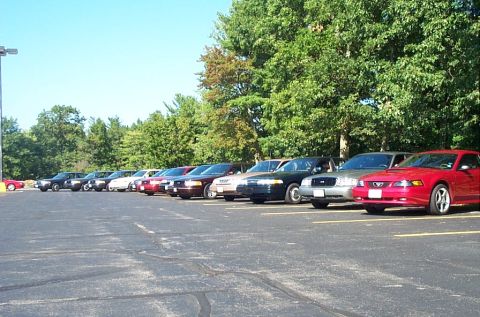 1991 Ford LTD Crown Victoria - Photograph of parked cars at an outdoor lot with a red Mustang, not a technical document.