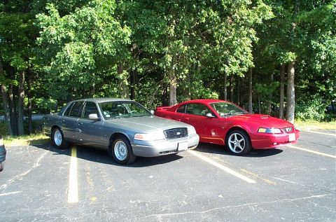 1991 Ford LTD Crown Victoria - Photograph of a silver Ford sedan parked beside a red Mustang, not a technical document.