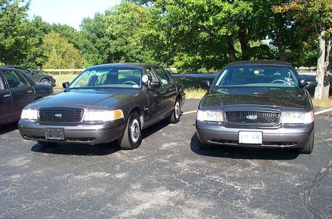 1991 Ford LTD Crown Victoria - Photograph of two gray Ford sedans parked front-facing, not a technical document.