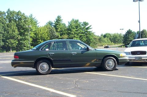 1991 Ford LTD Crown Victoria - Photograph of a green Ford sedan in profile in a lot, not a technical document.