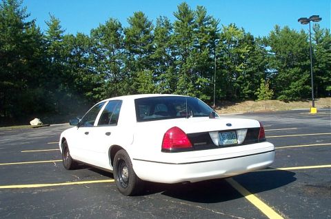 1991 Ford LTD Crown Victoria - Photograph of a white Crown Victoria parked near trees, not a technical document.