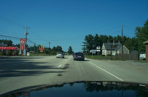 1991 Ford LTD Crown Victoria - Photograph of a roadway shot through a windshield with roadside businesses, not a technical document.