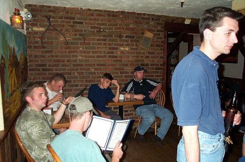 1991 Ford LTD Crown Victoria - Men socializing in a bar setting with brick walls and wooden accents.