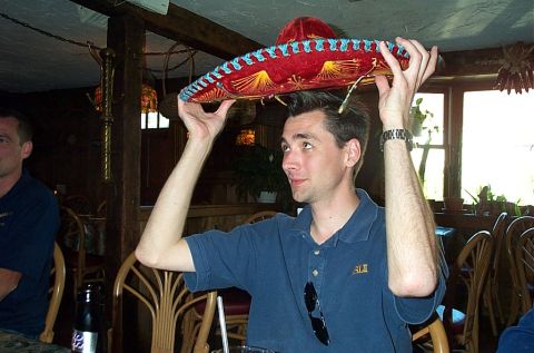 1991 Ford LTD Crown Victoria - A man balances a sombrero on his head while sitting at a table in a restaurant.