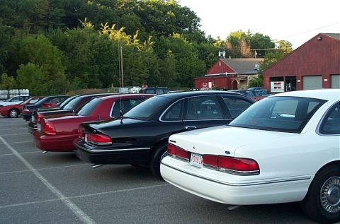 1991 Ford LTD Crown Victoria - A white Ford Crown Victoria is parked in a lot with other vehicles, showing its rear end and license plate.