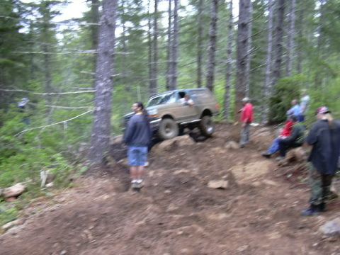 1991 Ford Bronco - A 1991 Ford Bronco navigates a steep, wooded trail during an off-road event.