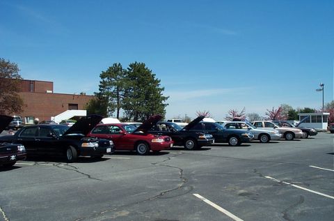 1991 Ford LTD Crown Victoria - A row of Ford Crown Victorias from 1991 are displayed with their hoods open under a clear blue sky.