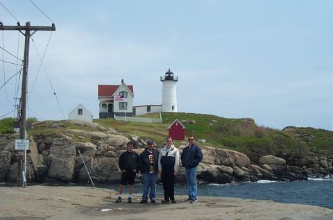 1991 Ford LTD Crown Victoria - A group of four men pose for a photo in front of the Nubble Lighthouse and keeper's house in York, Maine.