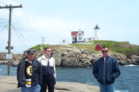 1991 Ford LTD Crown Victoria - Three men pose for a photo in front of a lighthouse on a rocky coastline.