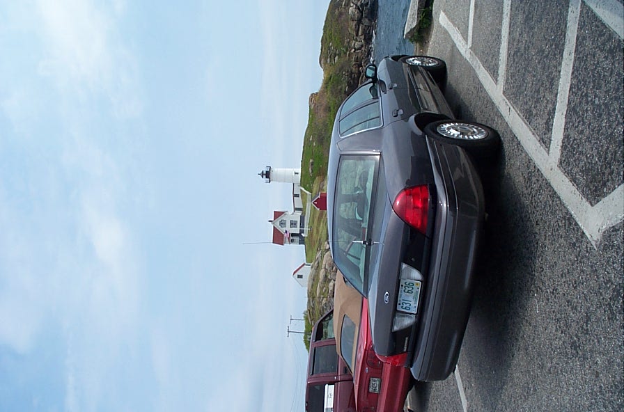 Dark sedan parked in a lot, rear view. License plate reads 637 LGS