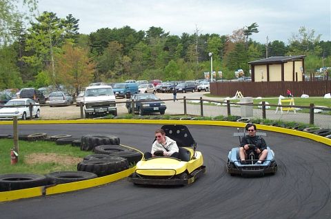 1991 Ford LTD Crown Victoria - Go-karts race on a track with a parking lot and trees visible in the background.
