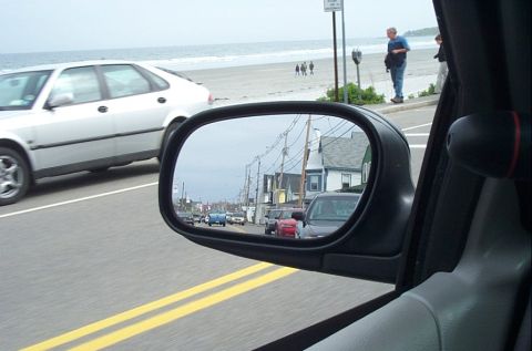 1991 Ford LTD Crown Victoria - Reflection in the side mirror shows a street scene with multiple vehicles and houses, alongside a silver car in the foreground.