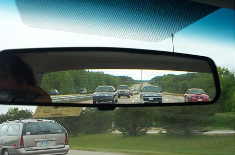 1991 Ford LTD Crown Victoria - Traffic moves along a highway, seen through the rearview mirror of a vehicle.