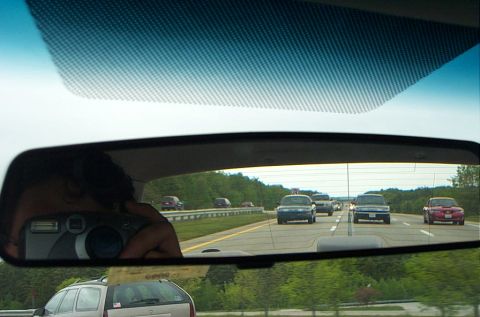 1991 Ford LTD Crown Victoria - Traffic moves along a highway, with several vehicles visible in the rearview mirror.