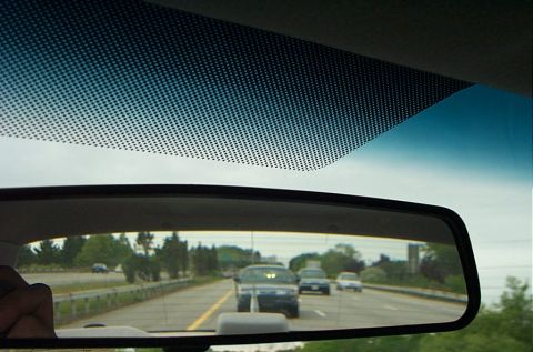 1991 Ford LTD Crown Victoria - Traffic moves along a highway, seen from the perspective of a driver looking in their rear-view mirror.