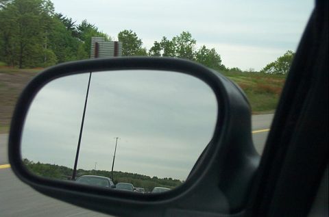 1991 Ford LTD Crown Victoria - Cars are seen in the reflection of a side view mirror while driving on a highway.