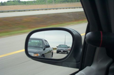 1991 Ford LTD Crown Victoria - Side mirror view of two cars driving on a highway.