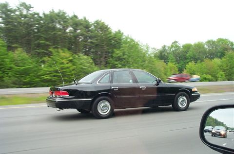 1991 Ford LTD Crown Victoria - A black 1991 Ford Crown Victoria LTD is seen driving on a highway, equipped with dual antennas.