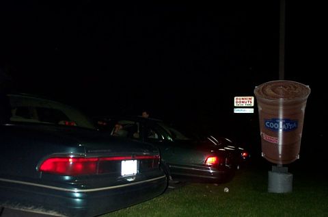 1991 Ford LTD Crown Victoria - Two cars are parked at a Dunkin' Donuts drive-thru at night, with a large drink cup advertisement visible.