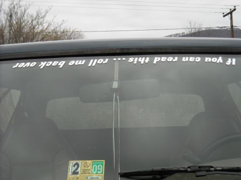 1994 Ford Bronco - The interior of a vehicle shows a humorous sticker on the rear windshield.
