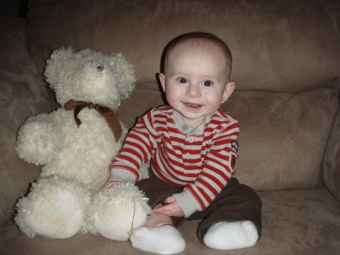 1997 Ford F-250 - A smiling baby sits with a teddy bear on a couch, with a watermark at the bottom right.