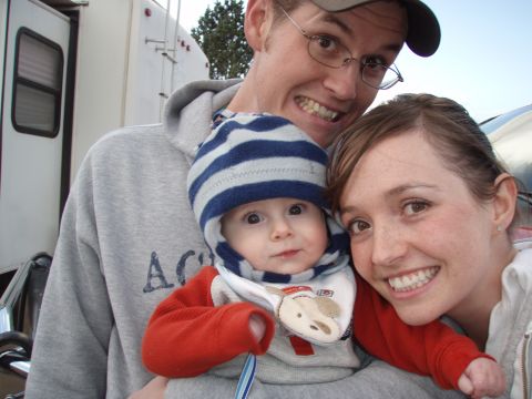 1997 Ford F-250 - A family smiles for a selfie while holding a baby, with a trailer in the background.
