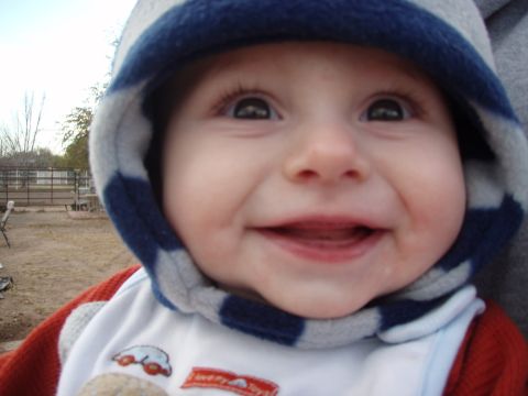 1997 Ford F-250 - A close-up of a smiling baby wearing a hooded jacket with blue and gray stripes.