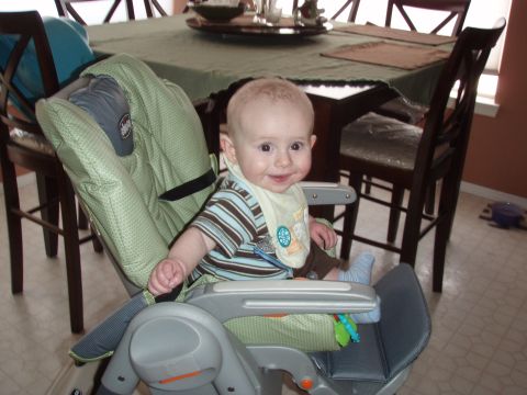 1997 Ford F-250 - A baby sits in a high chair in front of a dining table.